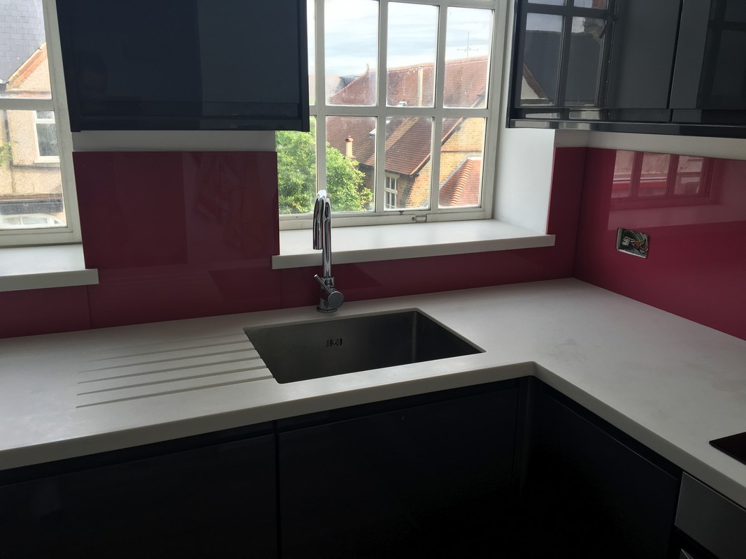 Deep plum coloured glass splashback in modern Waltham Abbey kitchen